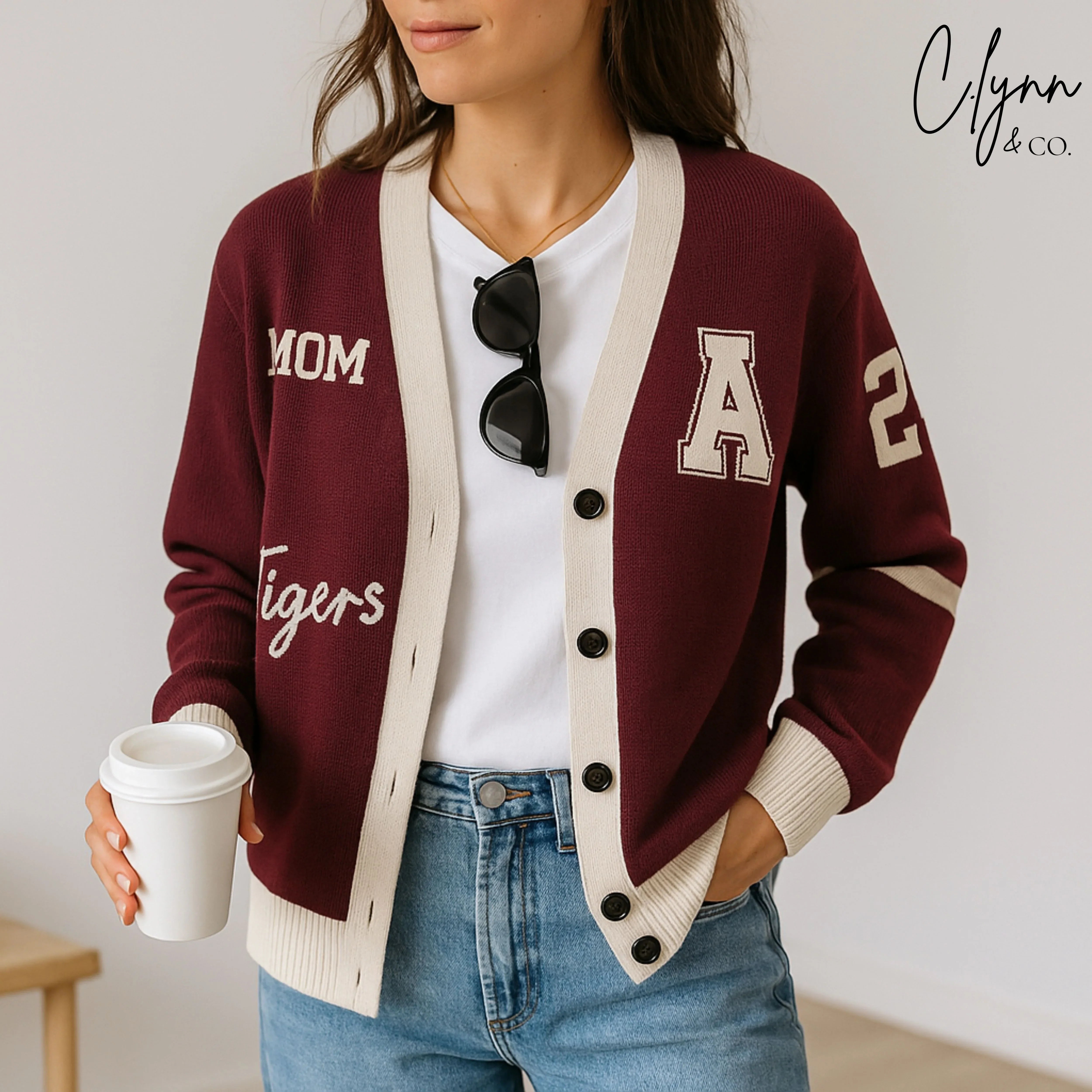 Woman wearing maroon varsity cardigan with 'Mom', 'Tigers', letter 'A', and number 2 patches.