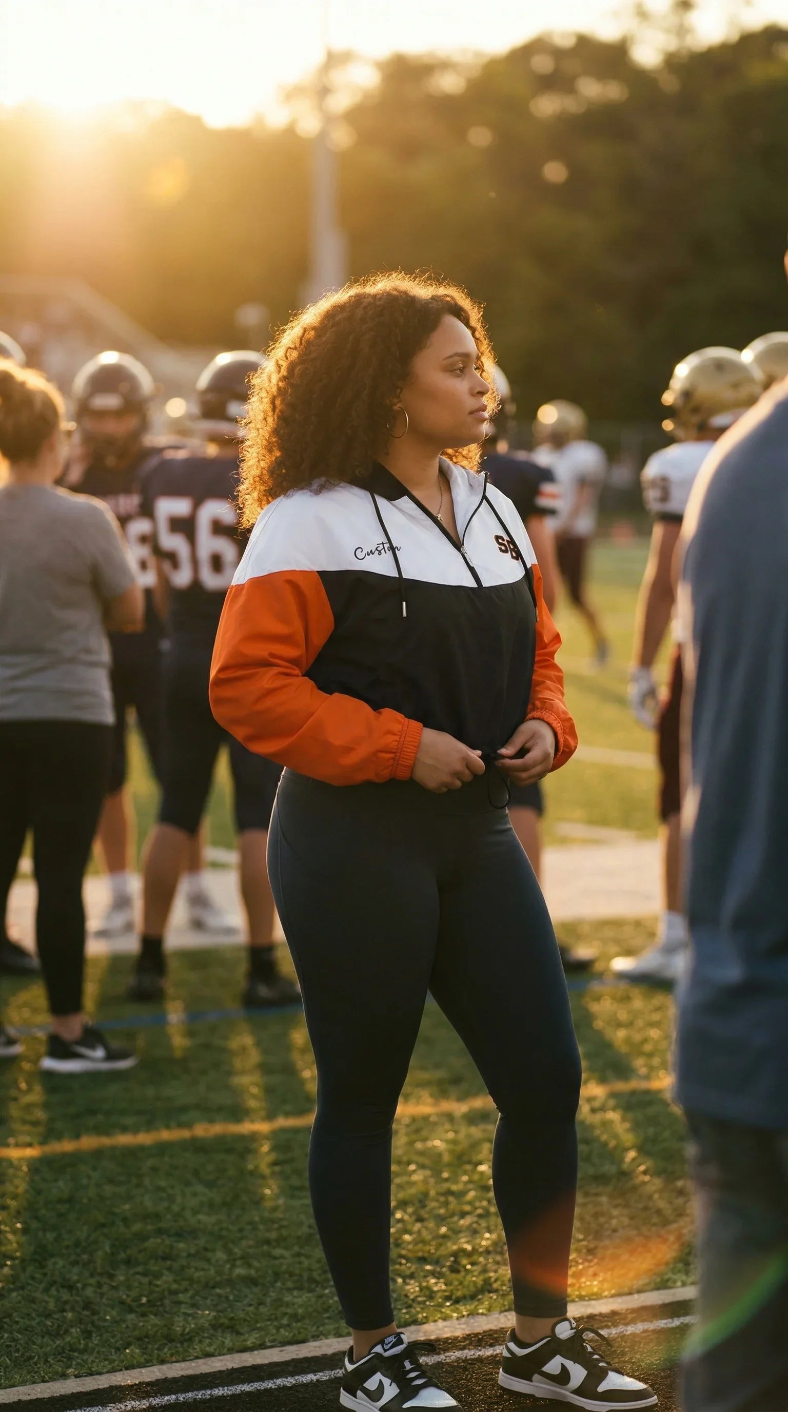 Person standing on a sports field with other players in the background