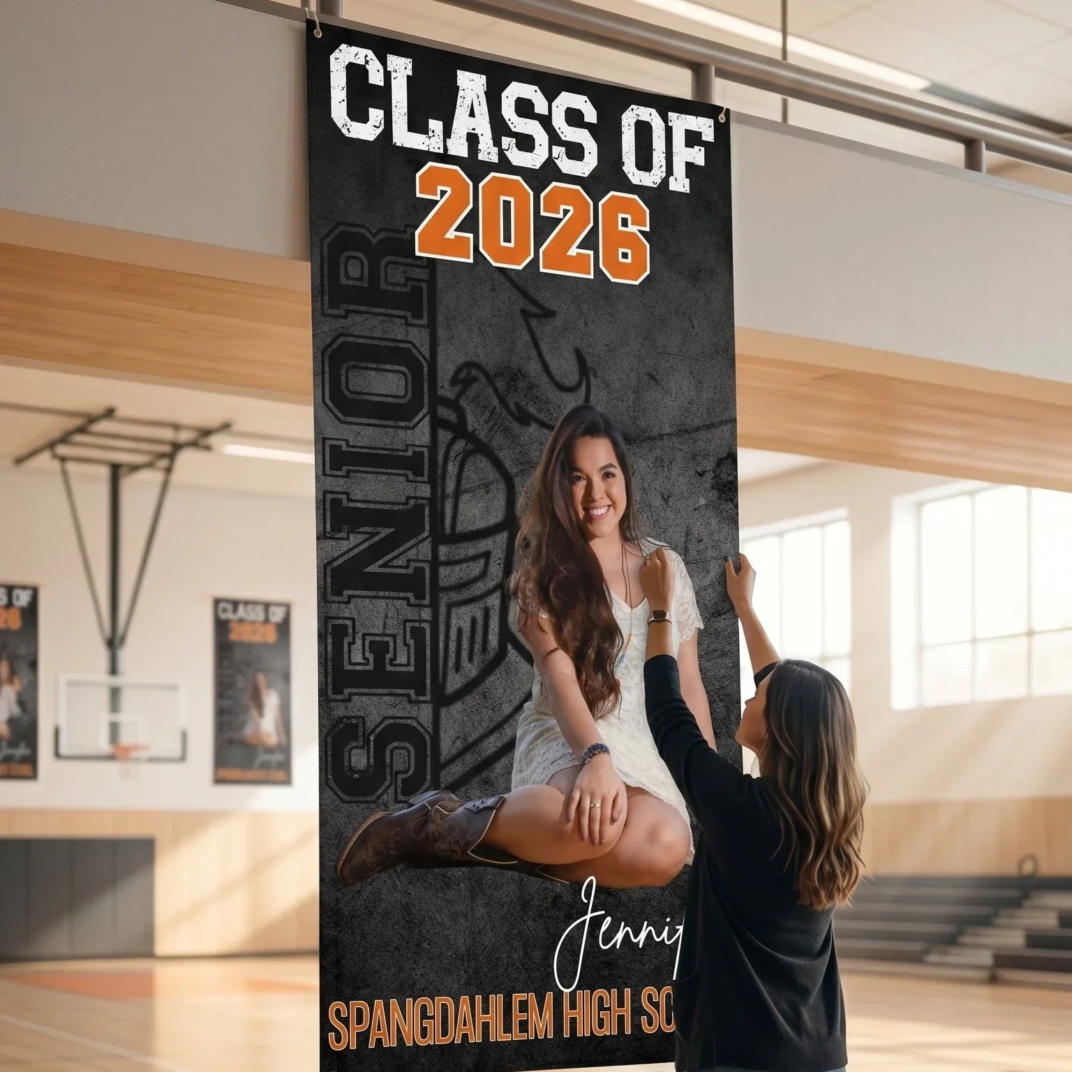 Person holding a Class of 2026 senior banner in a gymnasium.