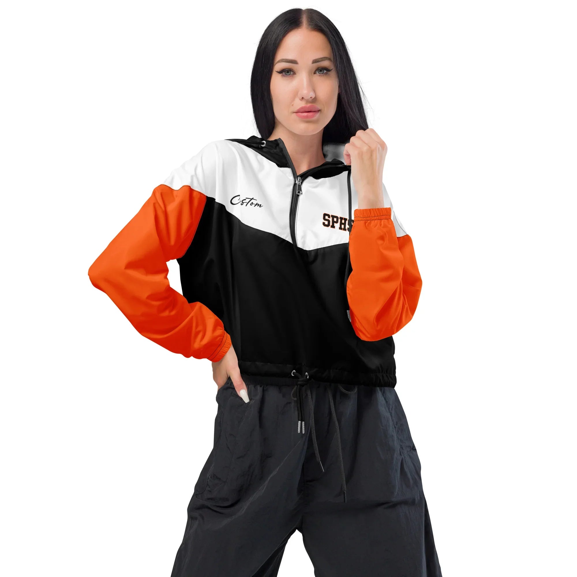 Woman wearing a black, orange, and white tracksuit with 'Cotopaxi' branding on a white background