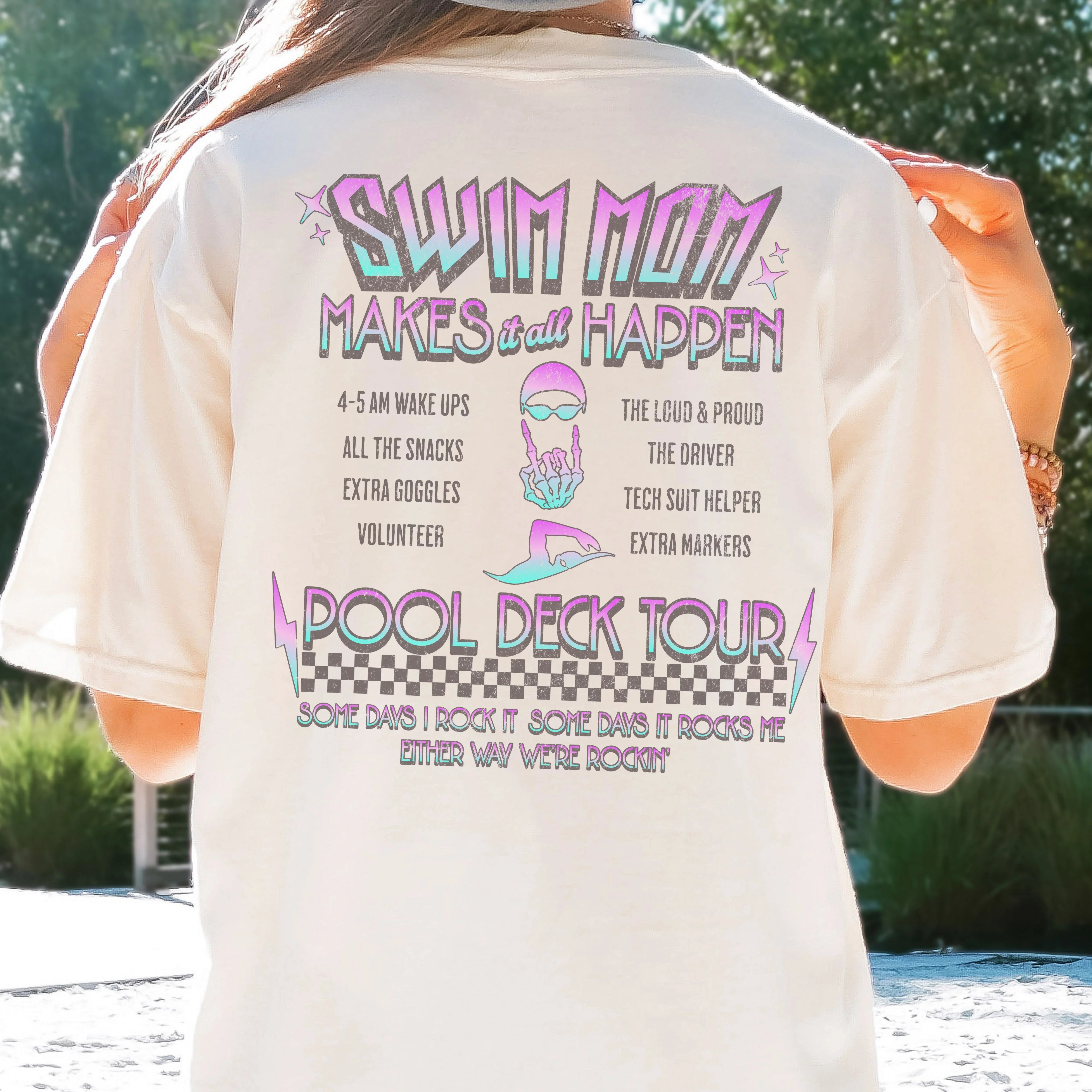 Person wearing a t-shirt with 'Swim Mom Makes it All Happen' text and graphics.