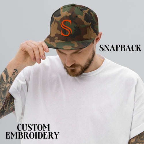 Man wearing camo snapback hat with orange S embroidery, plain white t-shirt, custom embroidery.