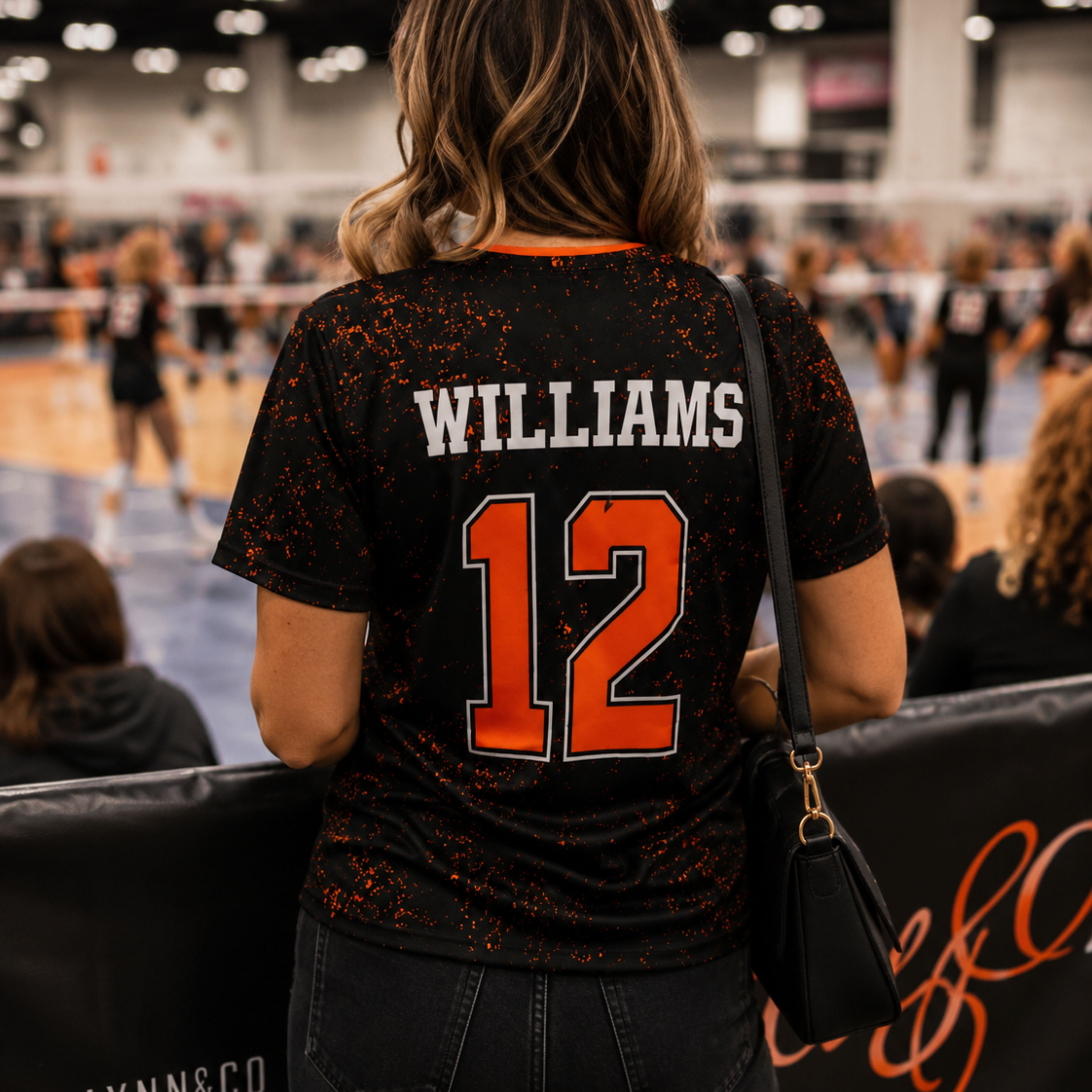 Back of a custom volleyball jersey showing player name and number 12 in orange