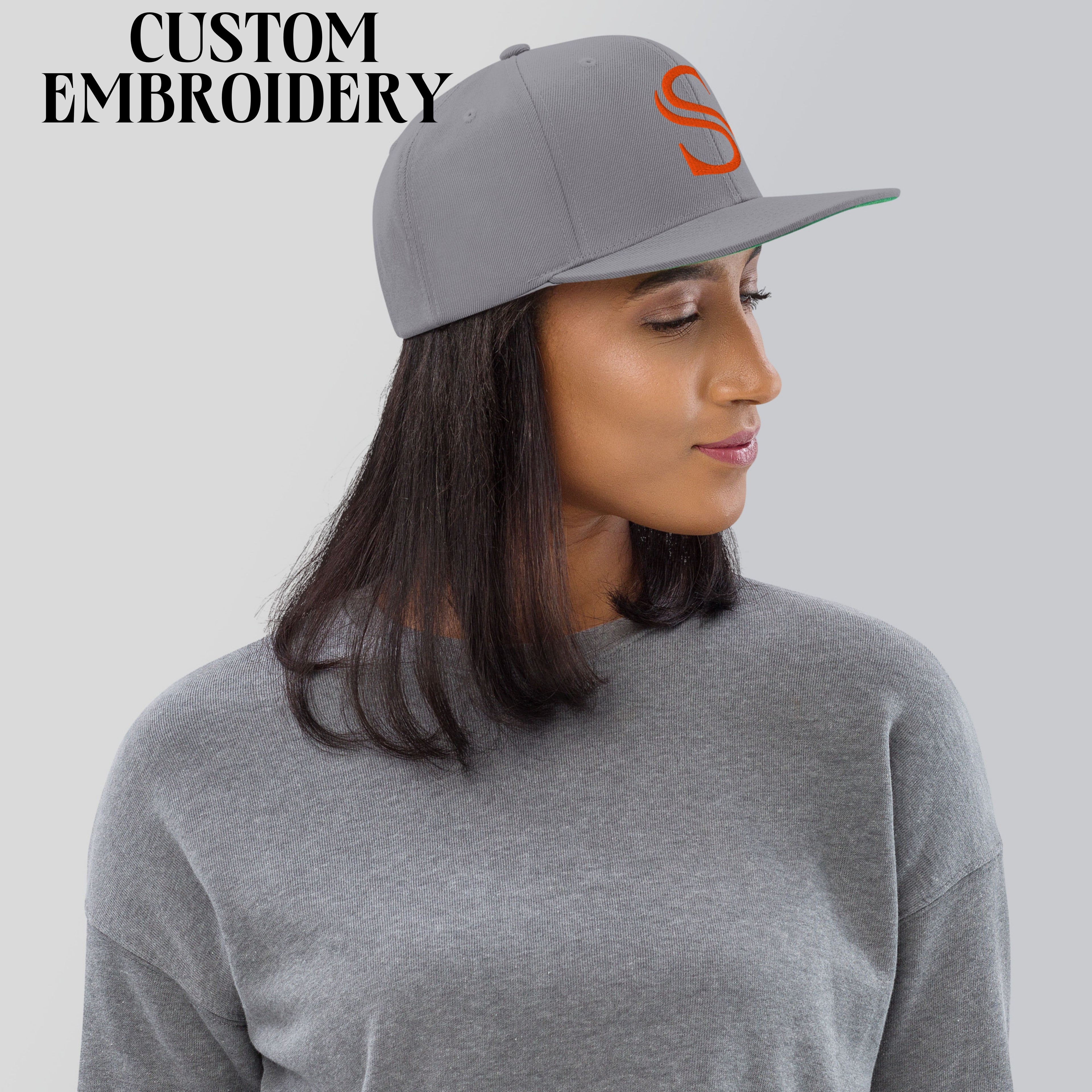 Woman wearing gray custom embroidered hat with orange S, matching gray sweatshirt