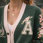 Green varsity cardigan with floral embroidery, letter A patch, tennis club motif, and pink trim