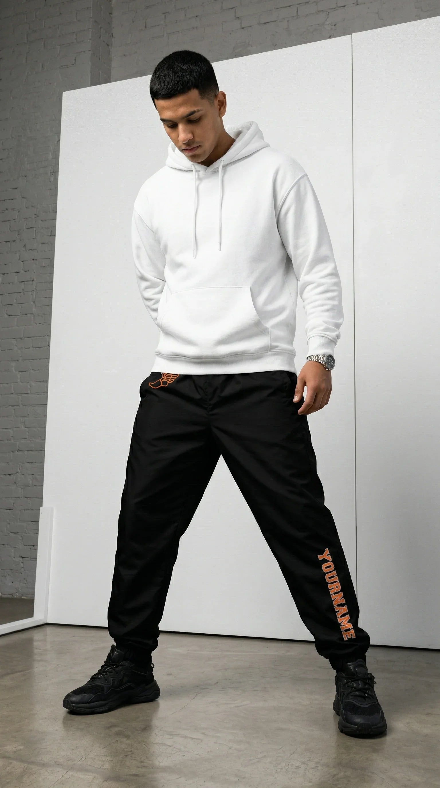 Person wearing a white hoodie and black pants with 'Topshop' branding, standing against a white wall.