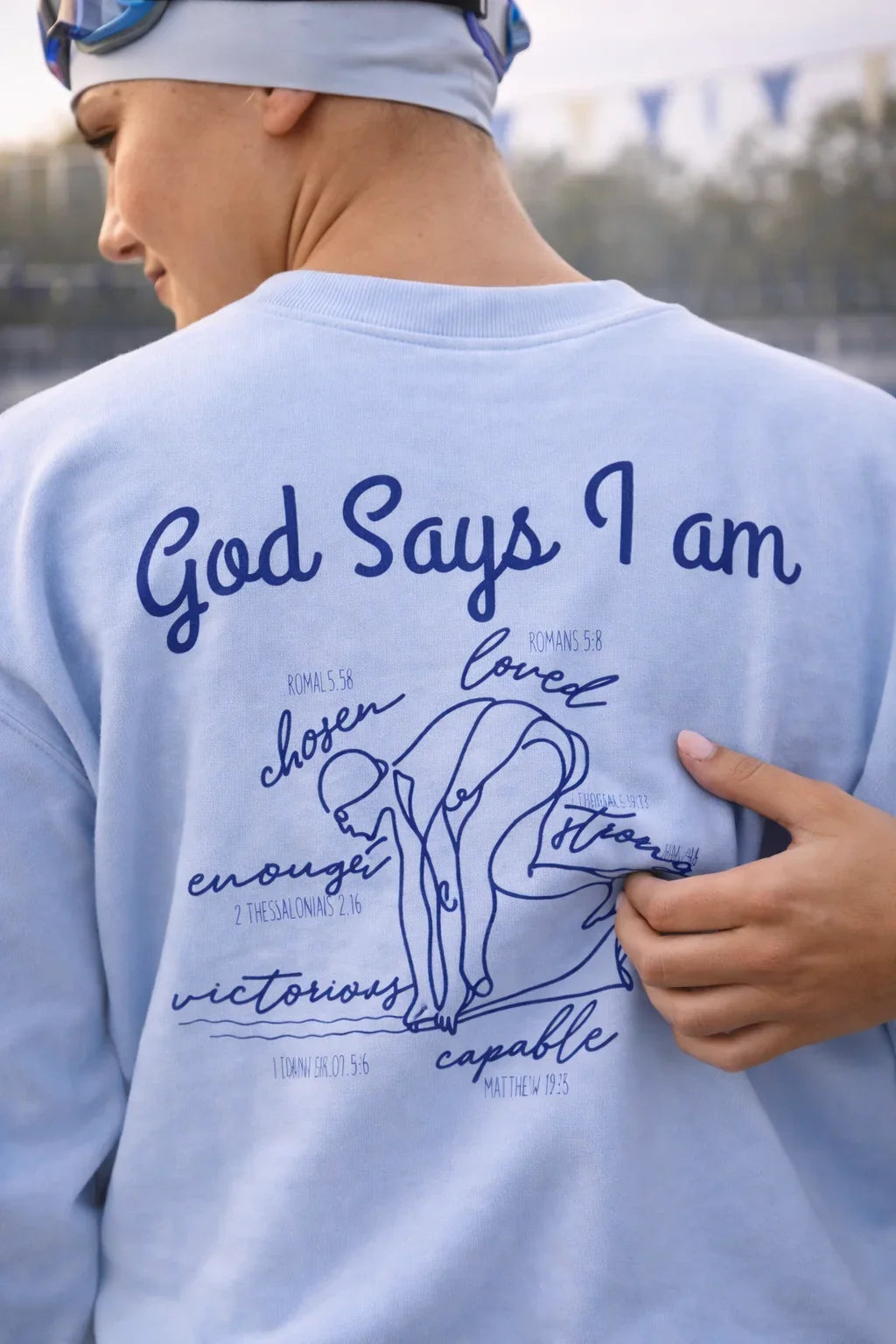 Person wearing a light blue t-shirt with motivational text and graphics on the back.