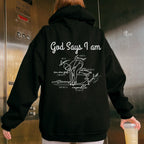 Person wearing a black hoodie with text and graphics on the back, standing in an elevator. God Says I Am Swimmer Faith Based Hoodie