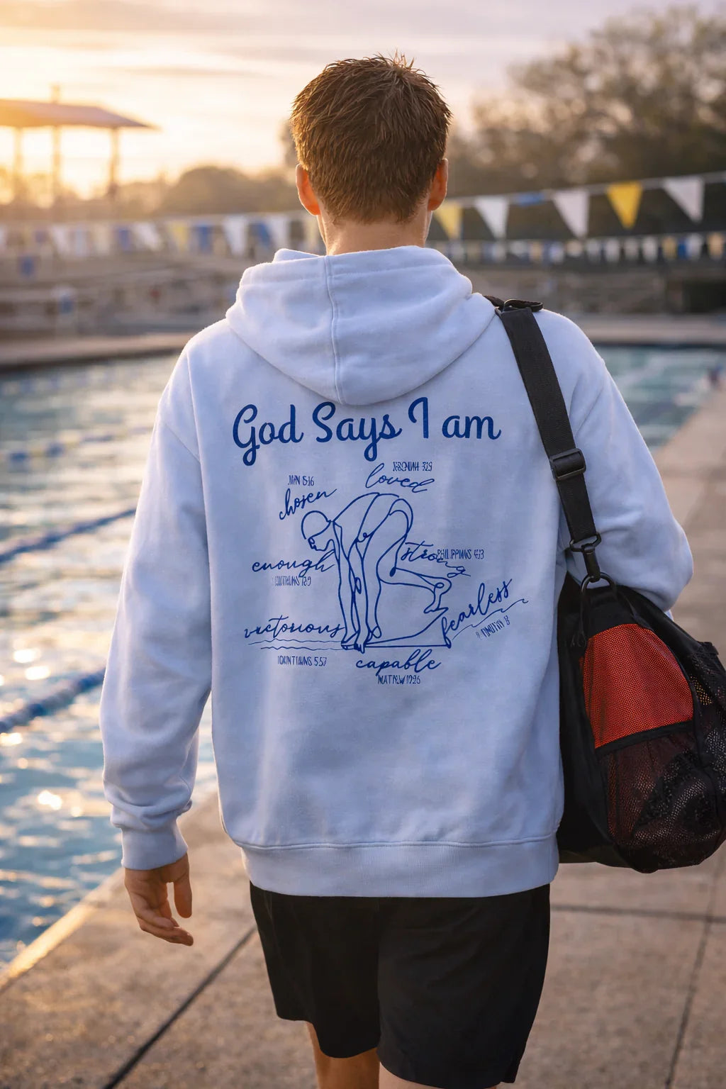 Person wearing a royal blue hoodie with God Says I am Faith based text and swimmer 