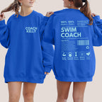 Two people wearing blue sweatshirts with 'Coach Kelly' on the front and 'Swim Coach' on the back.