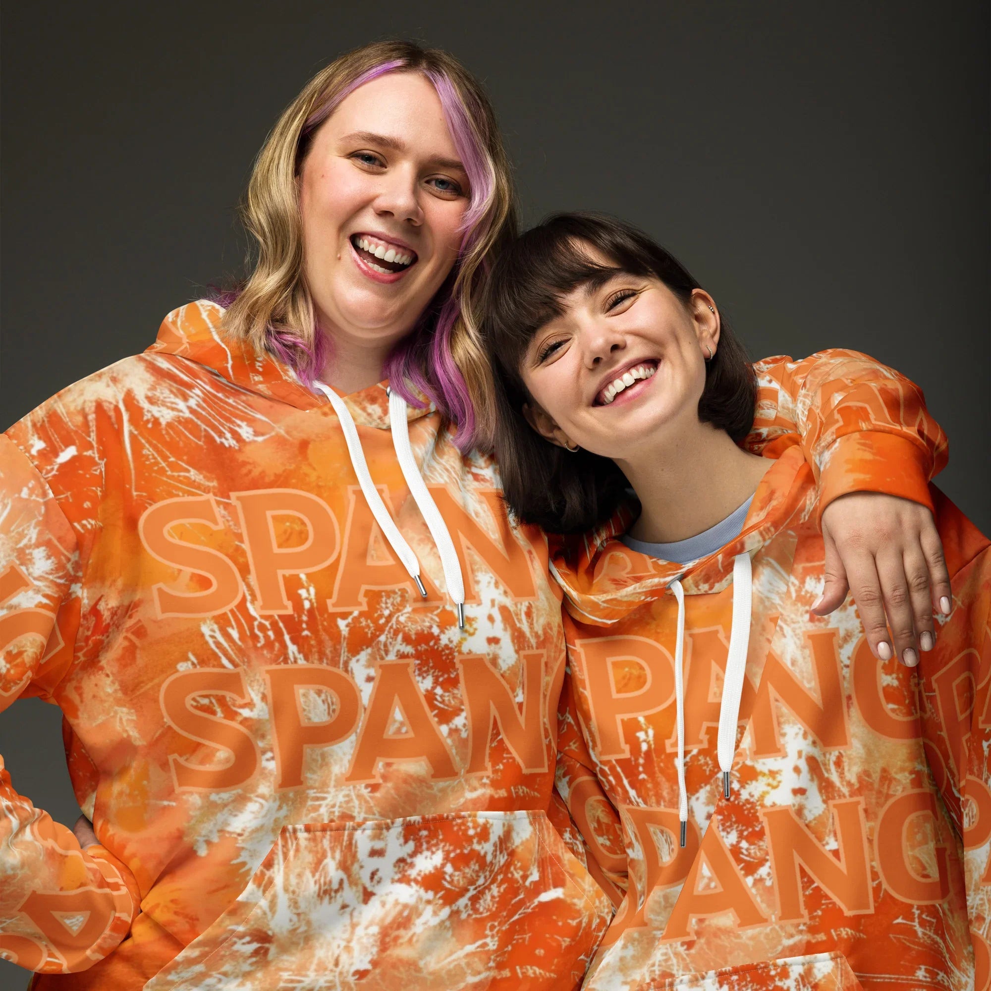 Two people wearing orange hoodies with 'custom text' printed on them against a dark background.