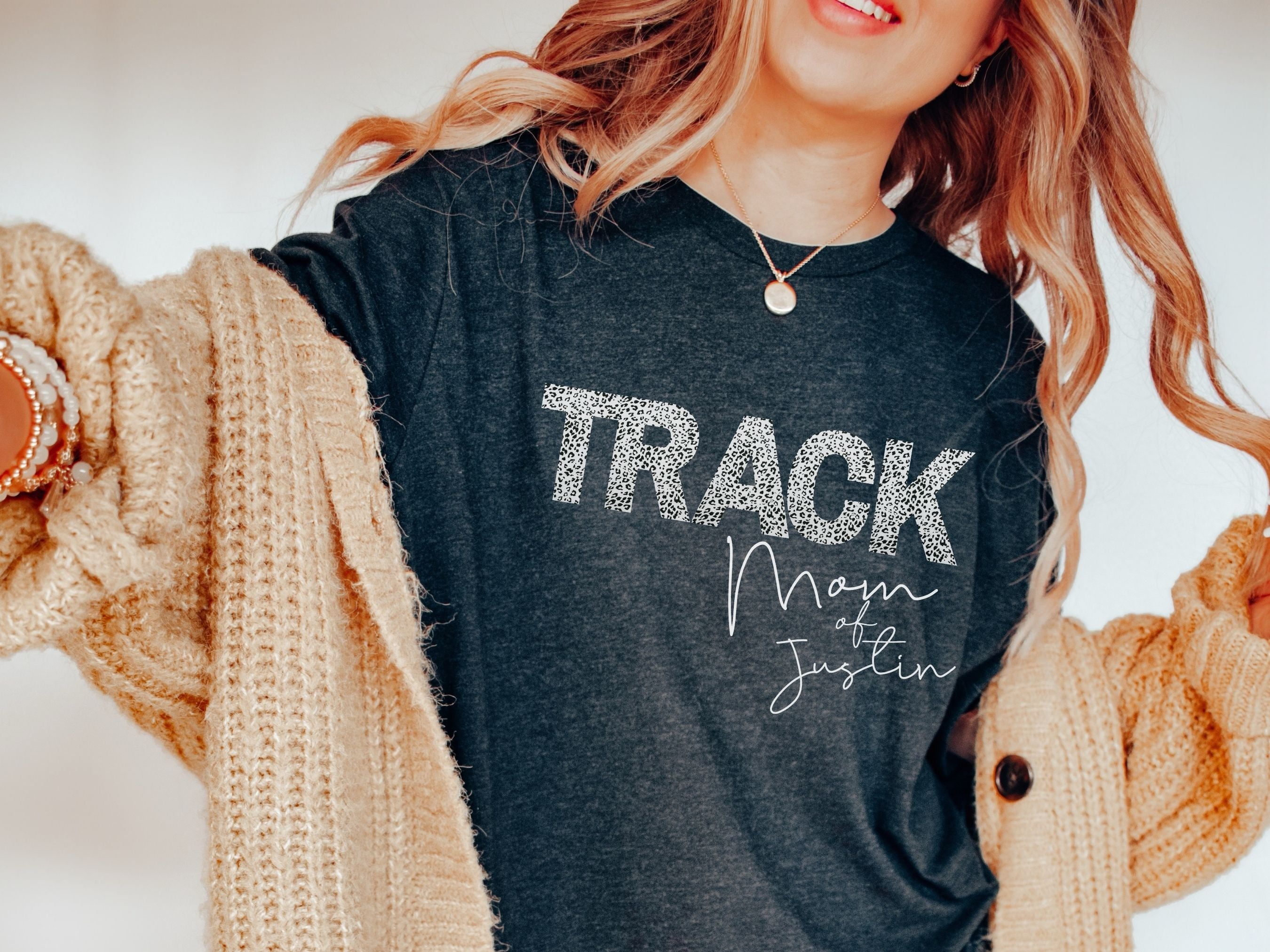 Person wearing a dark t-shirt with 'TRACK Main at Justin' text, draped in a beige sweater.