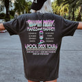 Person wearing a black t-shirt with colorful text and graphics on the back, standing outdoors.