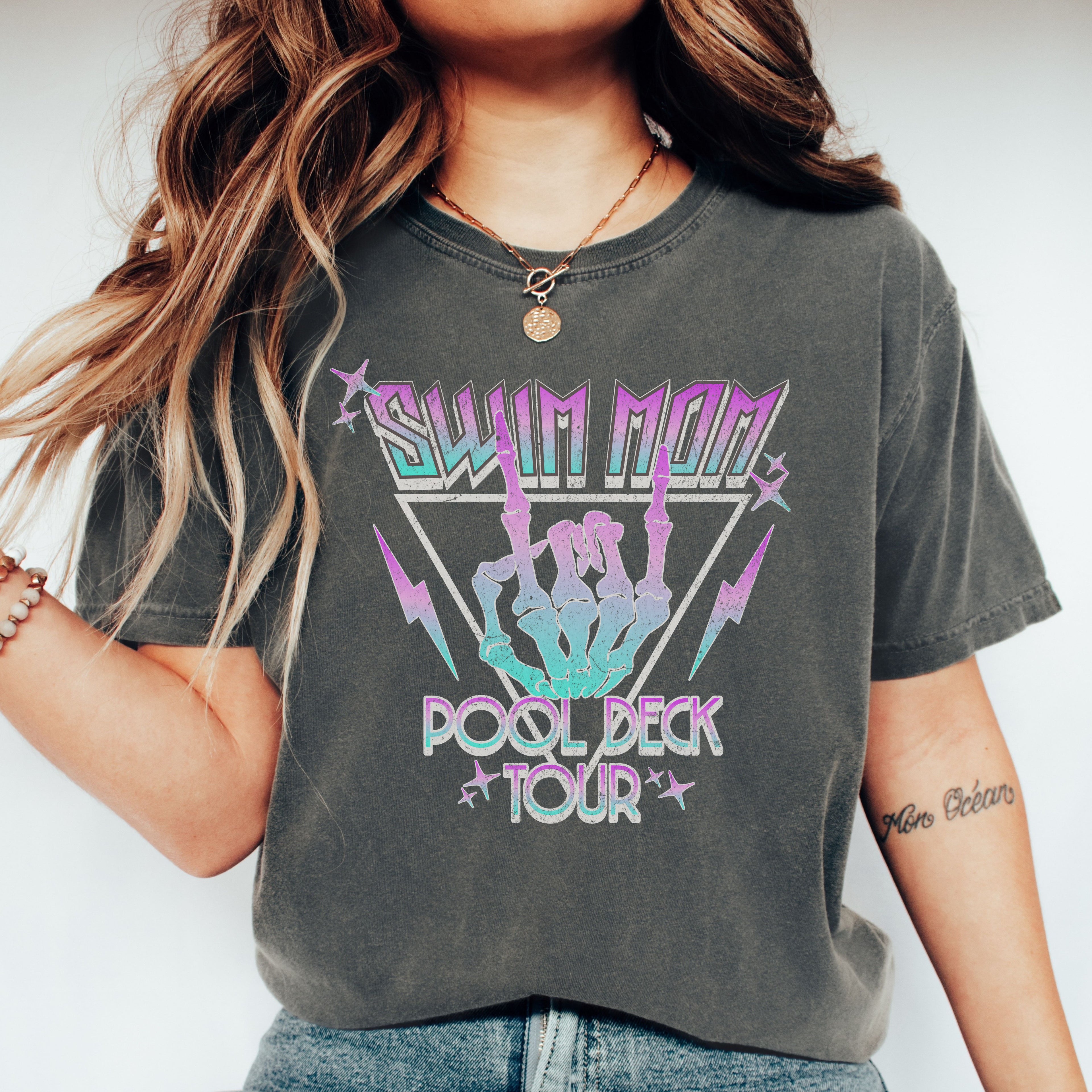 Person wearing a dark gray t-shirt with colorful graphic design and text.