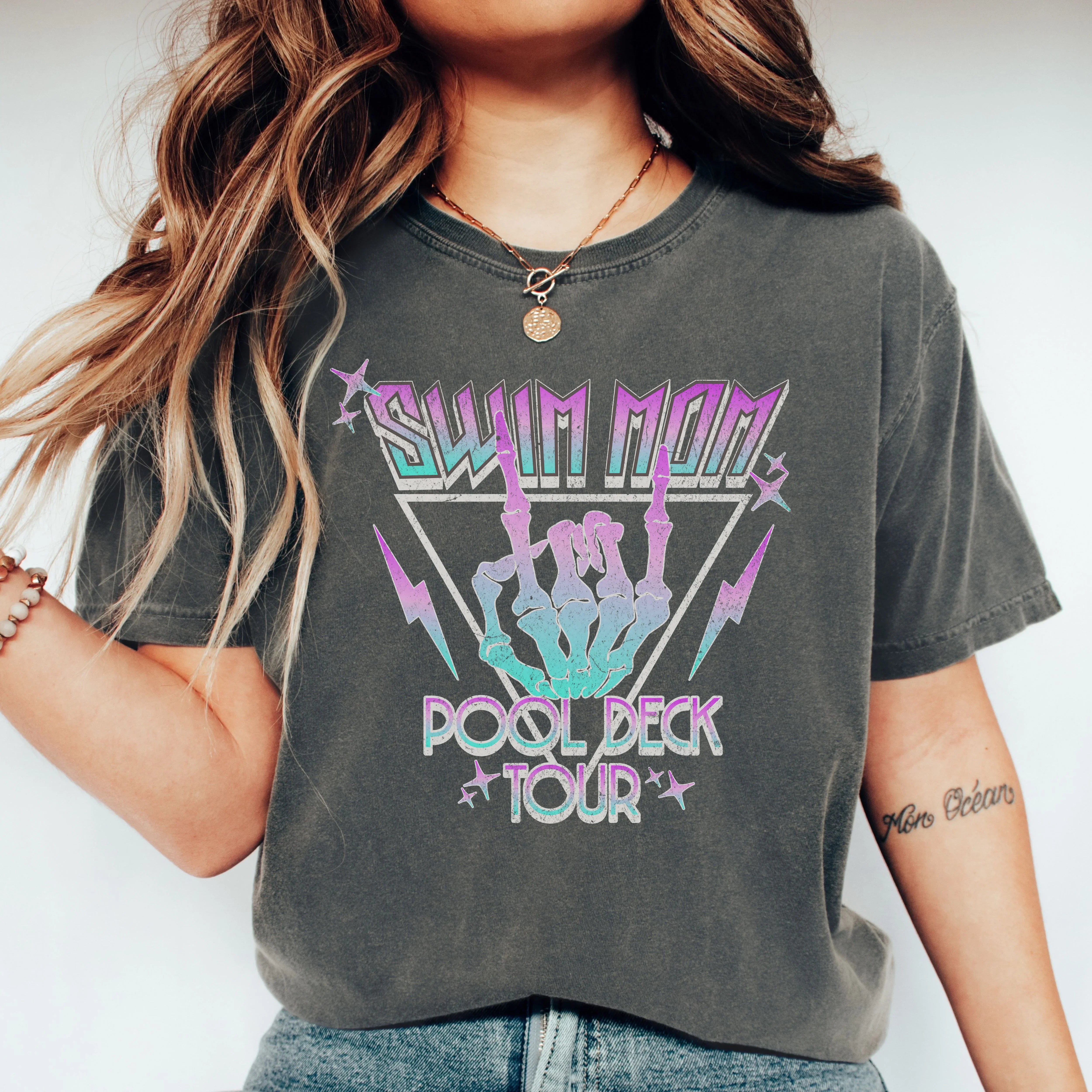 Person wearing a dark gray t-shirt with colorful graphic design and text.