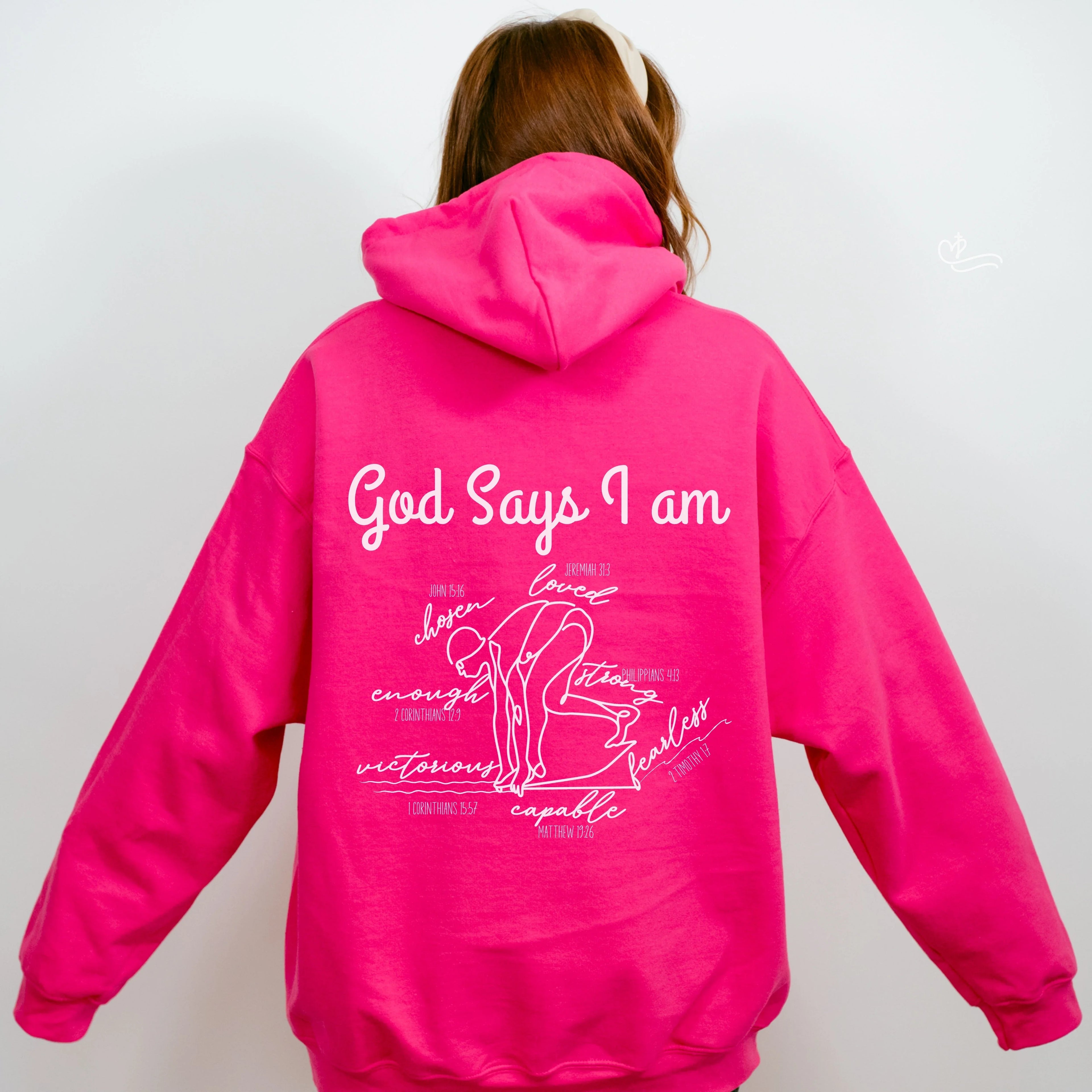 Person wearing a bright pink hoodie with God Says I am Faith based text and swimmer 
