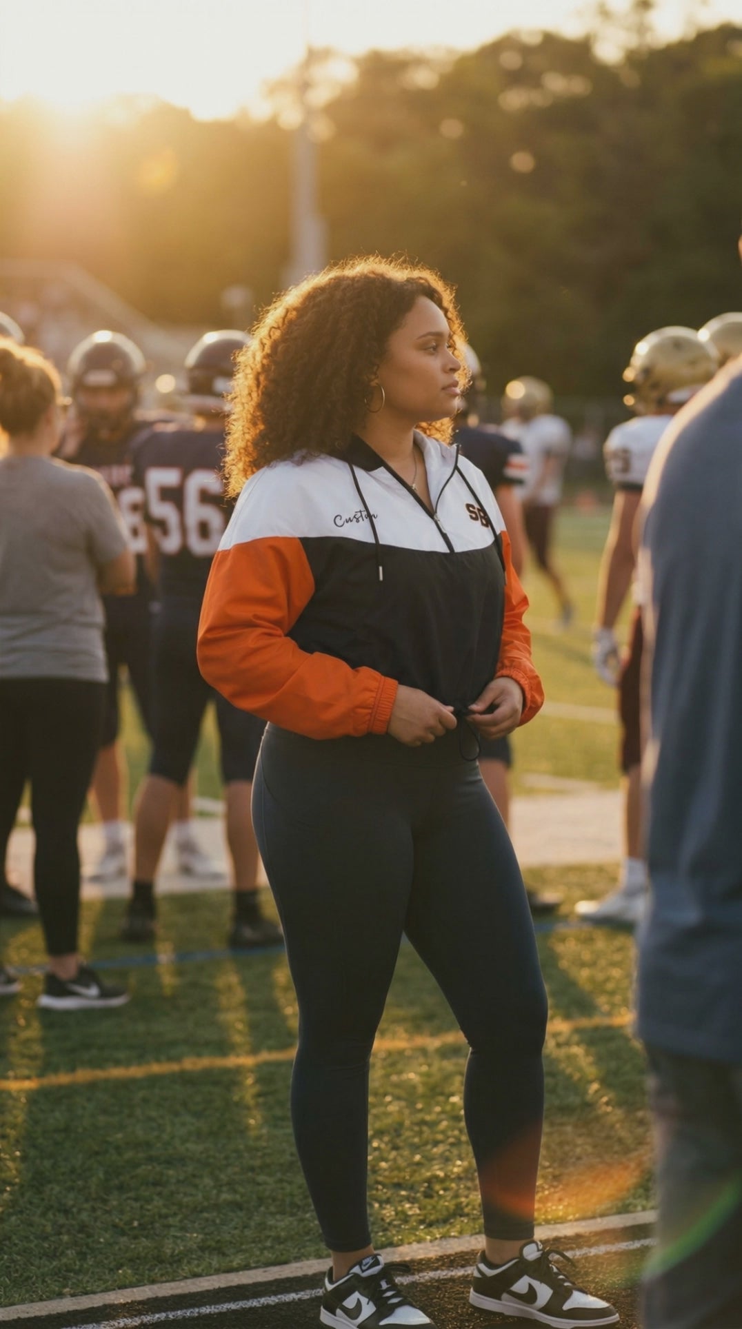 Custom Woman's Cropped Windbreaker Jacket Standing on a sports field