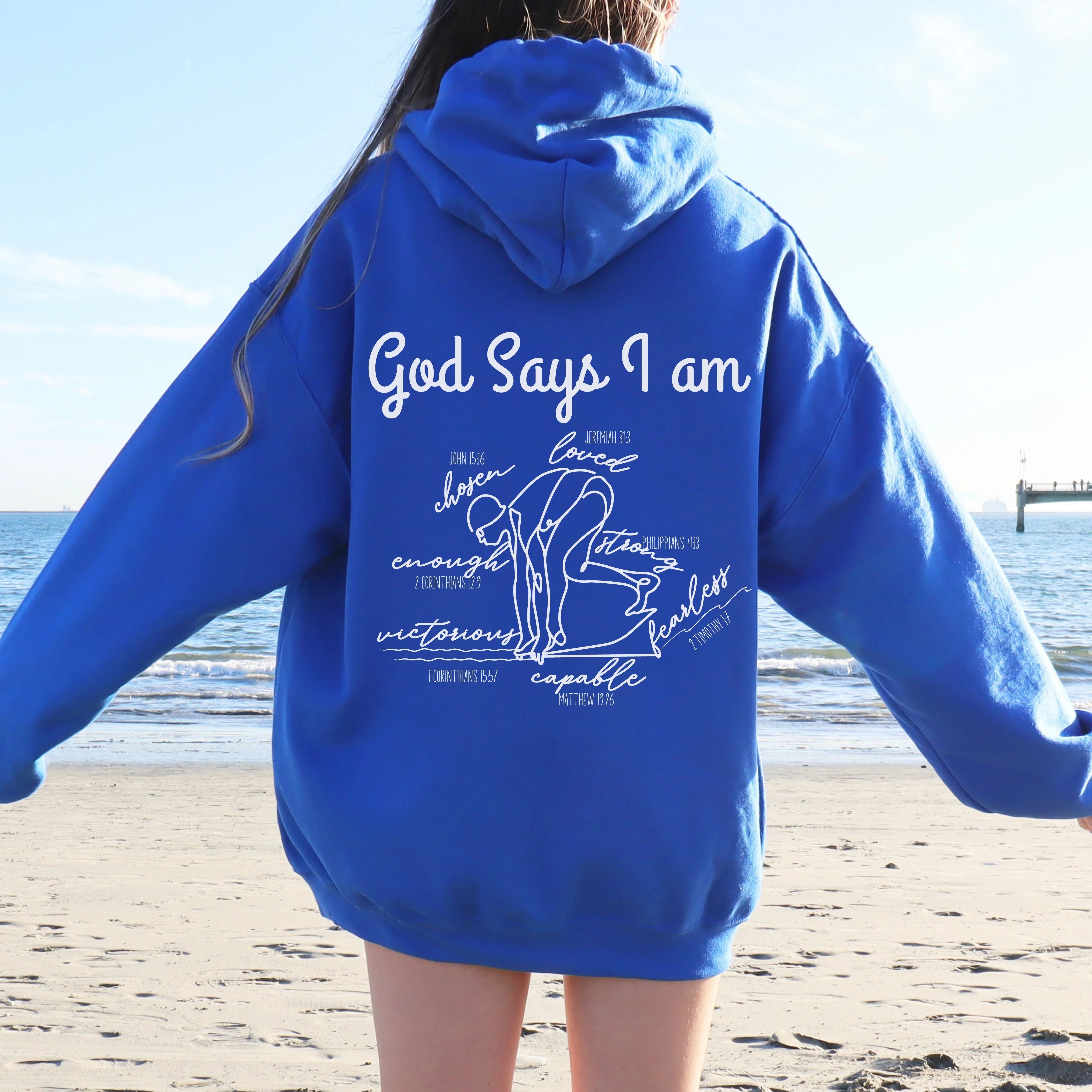 Person wearing a royal blue hoodie with God Says I am Faith based text and swimmer 